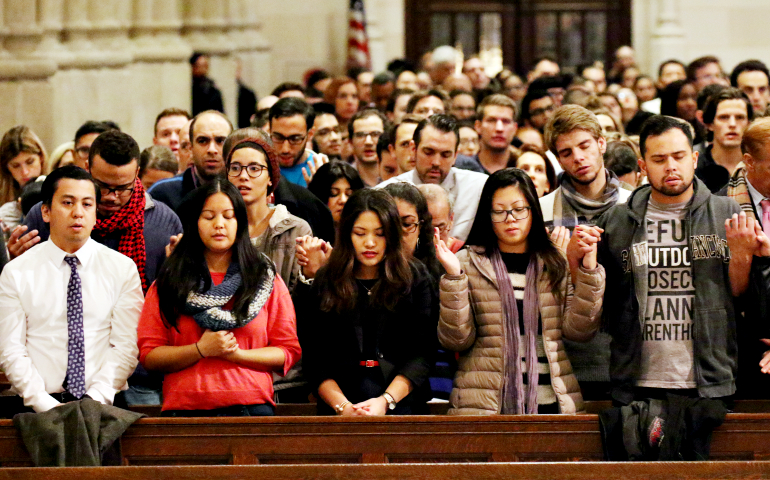People recite the Lord's Prayer during a Mass for young adults Dec. 7, 2016, at St. Patrick's Cathedral in New York City. (CNS/Gregory A. Shemitz)