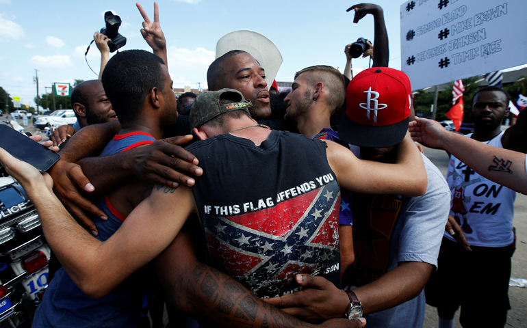 Men embrace after taking part in a prayer circle July 10 following a Black Lives Matter protest in the wake of multiple police shootings in Dallas. (CNS/Carlo Allegri, Reuters)