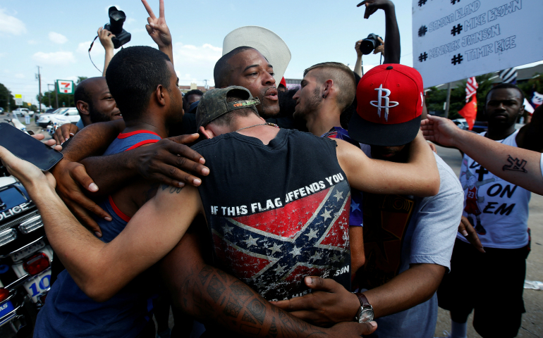 Men embrace after taking part in a prayer circle July 10 following a Black Lives Matter protest in the wake of multiple police shootings in Dallas. (CNS photo/Carlo Allegri, Reuters)