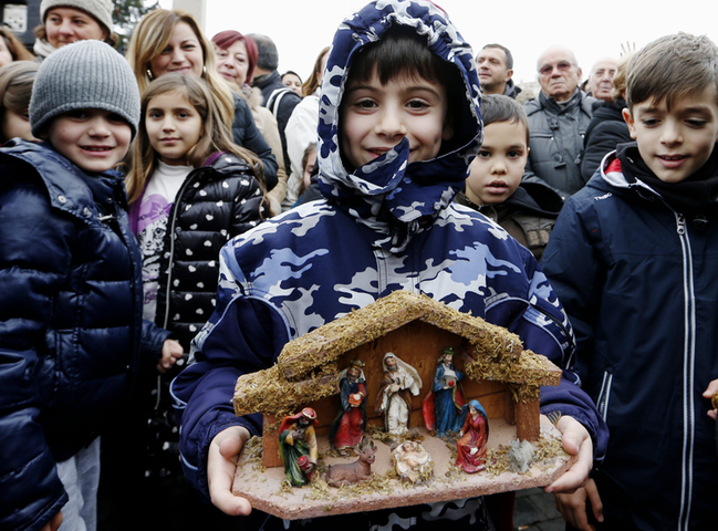 A boy holds his Nativity scene as Pope Francis leads the Angelus from the window of his apartment overlooking St. Peter's Square at the Vatican Dec. 11. (CNS/Paul Haring)
