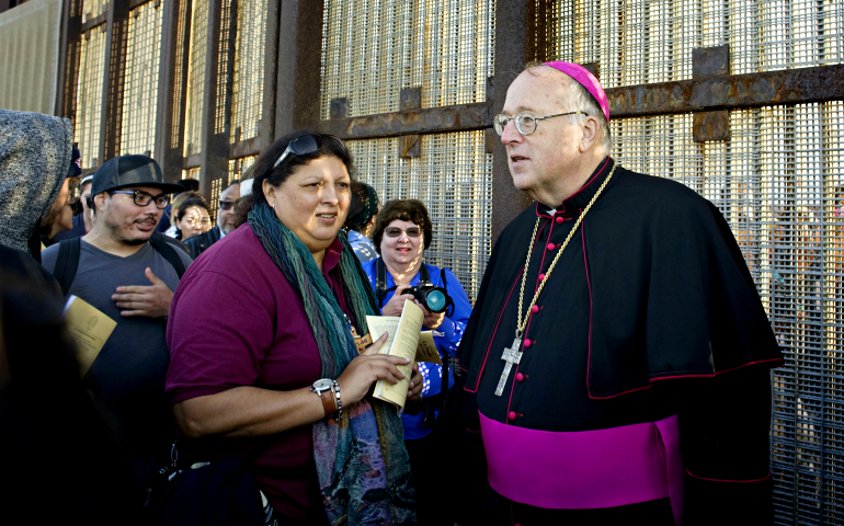 San Diego Bishop Robert McElroy speaks with people at the U.S.-Mexico border fence in San Diego Dec. 10 during the 23rd Posada Sin Fronteras (Posada Without Borders), an event honoring migrants. (CNS/David Maung)