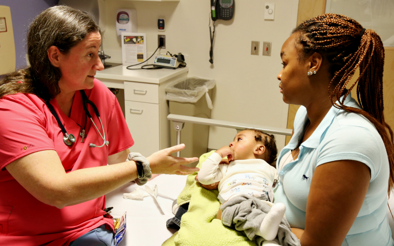 Mercy Sr. Karen Schneider, a pediatrician, talks with the mother of a child in the emergency room at Johns Hopkins Hospital in Baltimore in 2014. (CNS/Bob Roller)