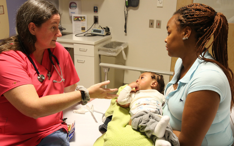 Mercy Sr. Karen Schneider, who is a pediatrician, talks with the mother of a child in the emergency room at Johns Hopkins Hospital in Baltimore in 2014. (CNS / Bob Roller) 