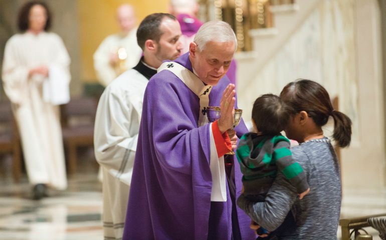 Cardinal Donald W. Wuerl of Washington blesses a child during a Dec. 18 Mass at St. Matthew's Cathedral commemorating the 50th anniversary of his ordination to the priesthood. (CNS photo/Jaclyn Lippelmann, Catholic Standard)