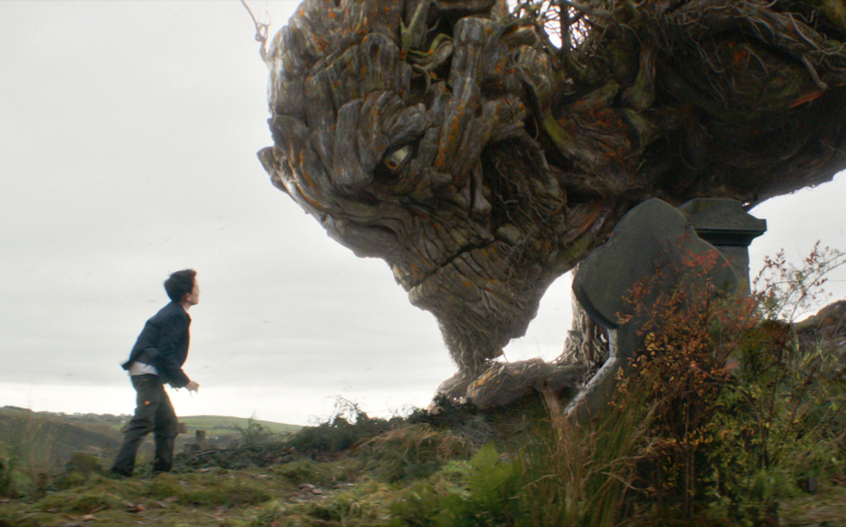 Conor, played by Lewis MacDougall, confronts the Monster, voiced by Liam Neeson, in the movie "A Monster Calls." (CNS/Focus Features)