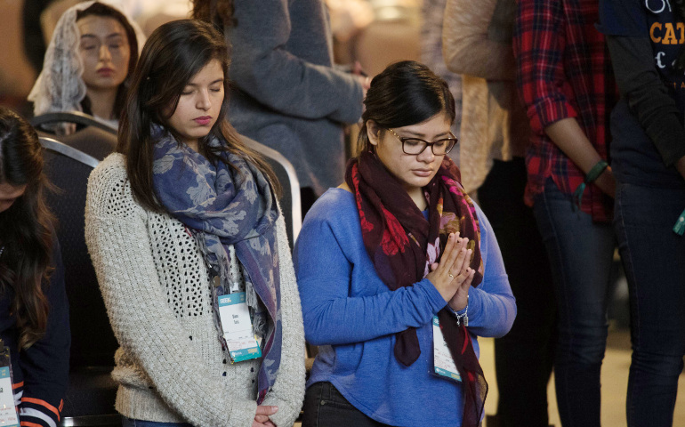 Young adults pray during a Mass during the Jan. 3-7 biennial SEEK conference at San Antonio's Henry B. Gonzalez Convention Center. The event was designed to bring evangelization efforts to college campuses. (CNS / courtesy FOCUS) 
