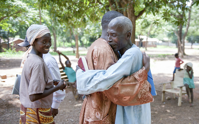 Villagers embrace in 2014 on the grounds of the Monastery of Boy Rabe in Bangui, Central African Republic. (CNS photo/Catianne Tijerina for Catholic Relief Services)