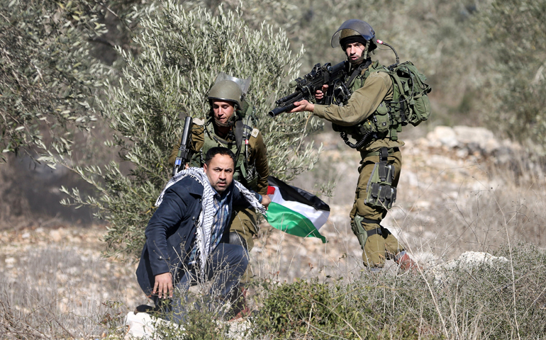 Israeli soldiers detain a Palestinian man during clashes following a protest against the nearby Jewish settlement in the West Bank village of Kafr. (CNS/Mohamad Torokman, Reuters)