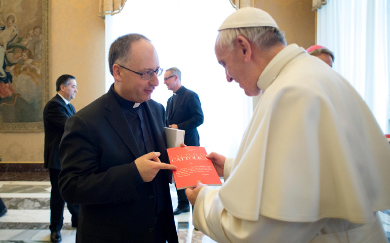 Pope Francis accepts an issue of La Civilta Cattolica from Fr. Antonio Spadaro during a Feb. 9 meeting with editors and staff. (CNS/L'Osservatore Romano, handout)