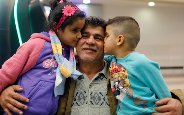 Nizar al-Qassab, an Iraqi Christian refugee from Mosul, gets a kiss from his children as they prepare to depart from Beirut international airport Feb. 8 en route to the United States. (CNS/EPA/Mohamed Azakir)