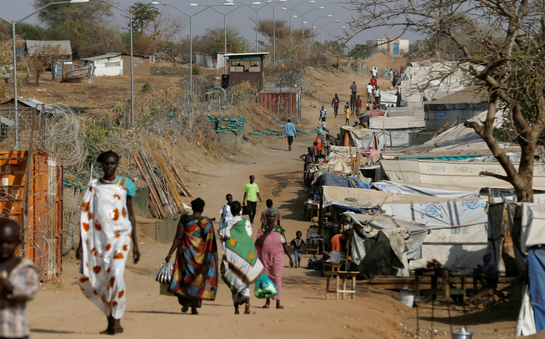 Internally displaced people walk on a road close to the outer perimeter of a United Nations mission Feb. 16 outside Juba, South Sudan. South Sudan's Catholic bishops have denounced government and rebel troops for attacking the civilian population and at times operating "scorched-earth" policies in defiance of international law. (CNS photo/Siegfried Modola, Reuters)