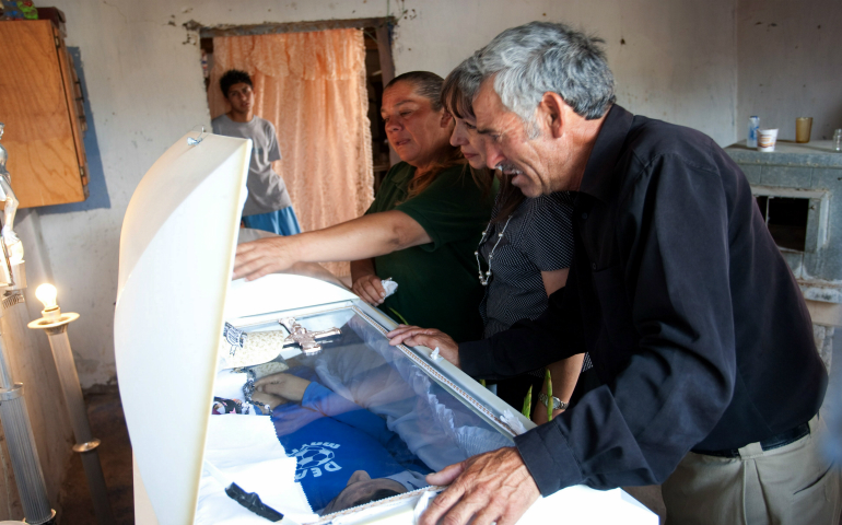 Maria Guadalupe Huereca, left, and Sergio Adrian Hernandez, look at the coffin of their son, 15-year-old Sergio Adrian Hernandez Guereca, during his 2010 wake in Ciudad Juarez, Mexico. The U.S. Supreme Court Feb. 21 heard oral arguments on whether Sergio's parents have the right to sue a U.S. Border Patrol agent who fired across the U.S.-Mexican border and killed their son. (CNS photo/Jesus Alcazar, EPA)