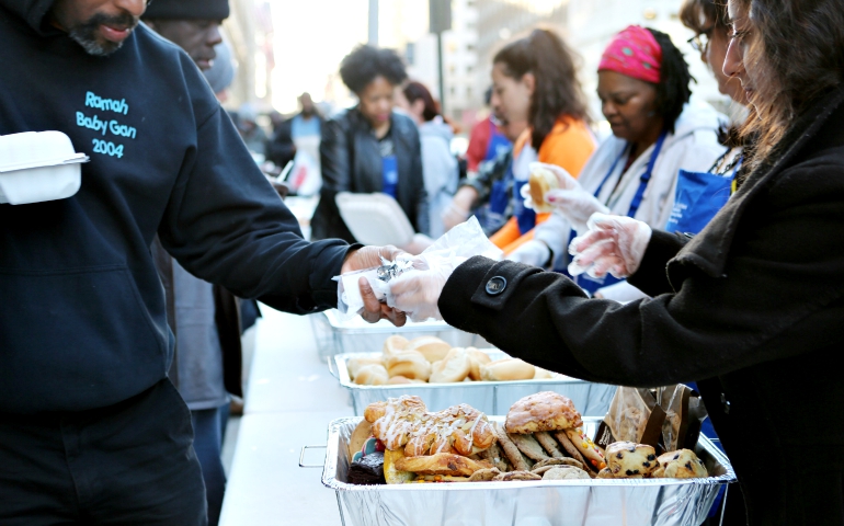 Volunteers with Catholic Charities' St. Maria's meals program in Washington serve dinner March 8 to the homeless. (CNS/Chaz Muth)