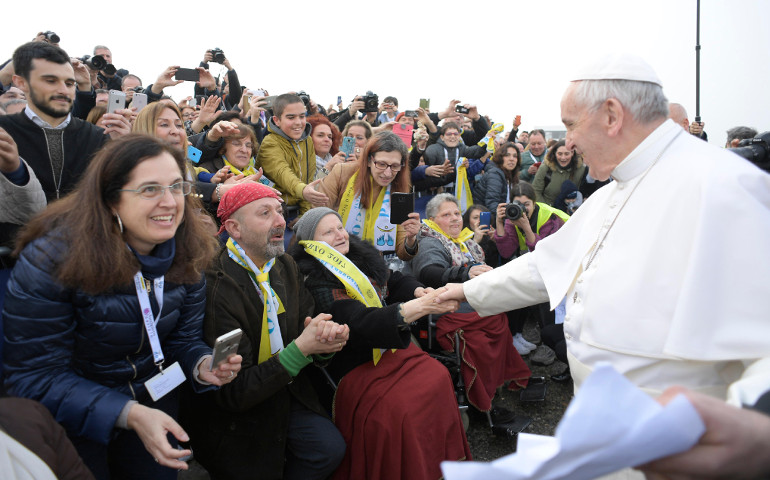 Pope Francis greets people as he visits the "White Houses," a housing development for the poor, on the outskirts of Milan March 25. (CNS/L'Osservatore Romano)