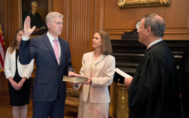 U.S. Chief Justice John Roberts, right, administers the constitutional oath to Judge Neil Gorsuch as his wife, Louise, holds the Bible during an April 10 private ceremony at the Supreme Court in Washington. (CNS photo/U.S. Supreme Court via Reuters)
