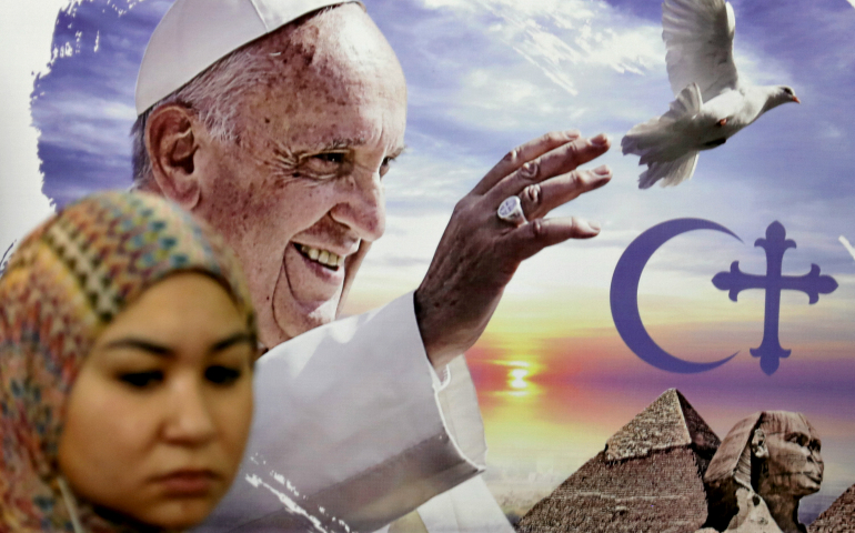 An Egyptian woman stands in front of a poster of Pope Francis April 6 in Cairo. (CNS/Reuters/Mohamed Abd El Ghany)