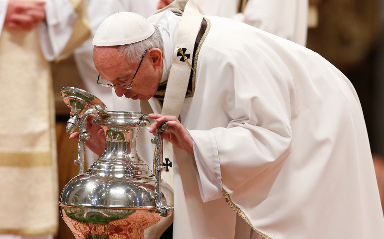 Pope Francis breathes over chrism oil, a gesture symbolizing the infusion of the Holy Spirit, during the Holy Thursday chrism Mass in St. Peter's Basilica at the Vatican April 13. (CNS/Paul Haring)