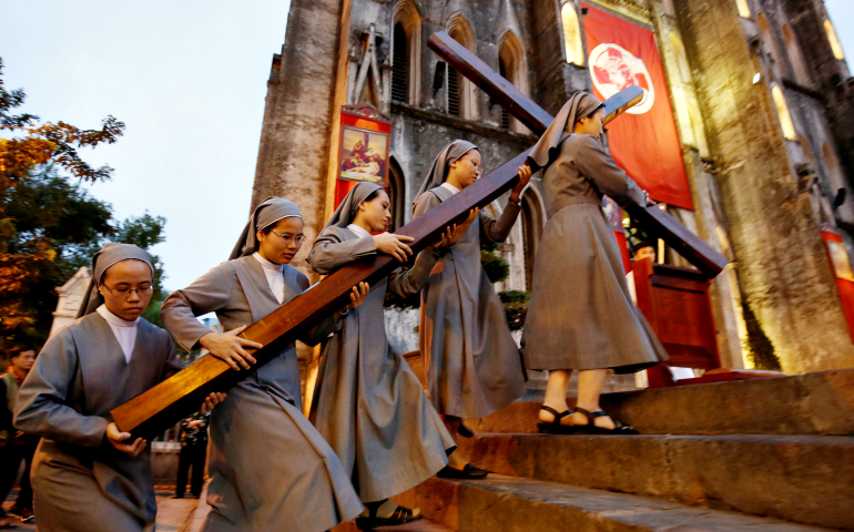 Nuns carry a large wooden cross into St. Joseph's Cathedral April 14 in Hanoi, Vietnam, to celebrate Good Friday services. (CNS/Reuters/Kham)