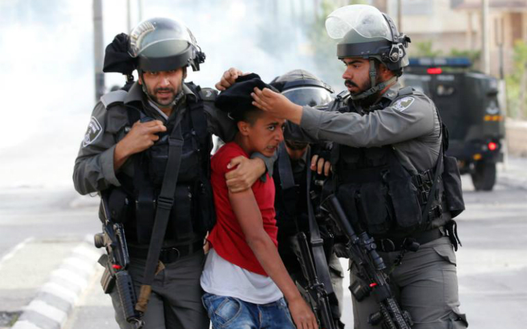 Israeli border policemen in Bethlehem, West Bank, detain a Palestinian protester in support of Palistinians in Israeli jails April 27. (CNS photo/Ammar Awad, Reuters)