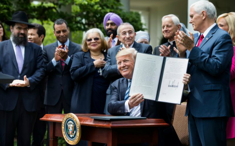 President Donald Trump shows his signed Executive Order on Promoting Free Speech and Religious Liberty during a National Day of Prayer event at the White House in Washington May 4. (CNS photo/Jim Lo Scalzo, EPA)