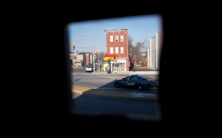 A police car is seen through the door window at St. Peter Claver Church rectory in Baltimore March 9. (CNS/Tyler Orsburn)