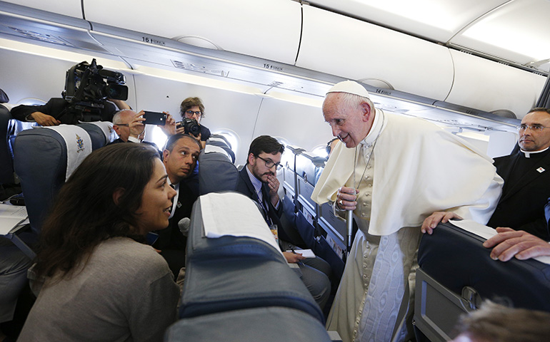 Pope Francis listens to a question from Joana Haderer of LUSA as he speaks with journalists aboard his flight from Portugal to Rome May 13; Joshua J. McElwee, NCR Vatican correspondent, pictured third from right (CNS/Paul Haring)