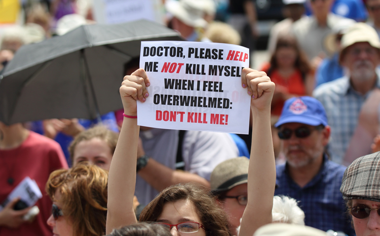 A woman holds up a sign during a rally against assisted suicide in 2016 on Parliament Hill in Ottawa, Ontario. (CNS/Art Babych)
