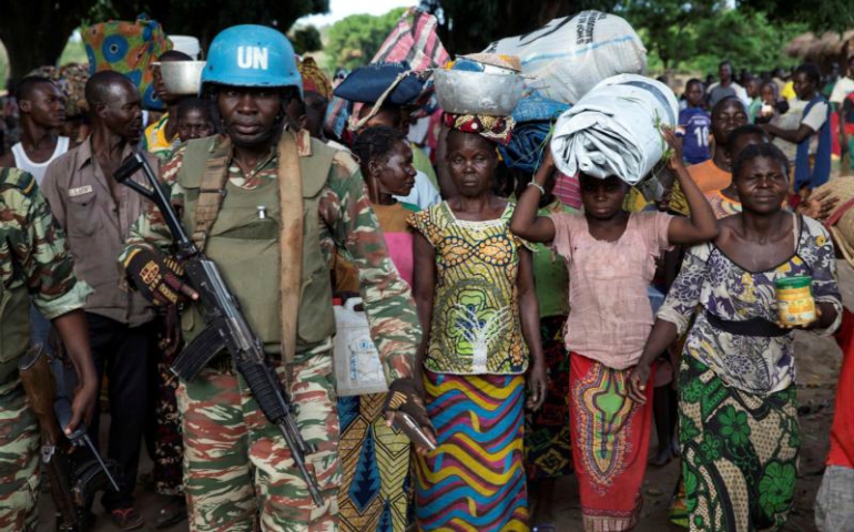 A U.N. peacekeeping soldier guards women fleeing Zike, Central African Republic, as they arrive April 26 in the village of Bambara. (CNS/Baz Ratner, Reuters)