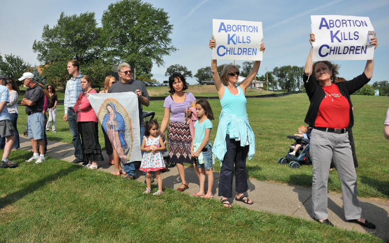 People hold pro-life signs in front of Planned Parenthood in Bettendorf, Iowa, in 2015. (CNS/Lindsay Steele, The Catholic Messenger) 