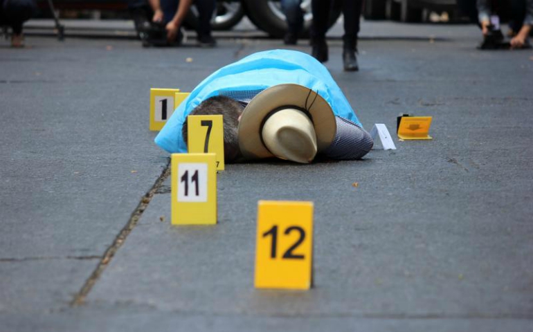 Evidence identifiers are placed next to the body of journalist Javier Valdez at a crime scene May 15 in Culiacan, Mexico. Valdez was pulled from his car and shot twelve times May 15 in Culiacan, a city currently consumed by drug cartel violence. (CNS/Jesus Bustamante, Reuters)