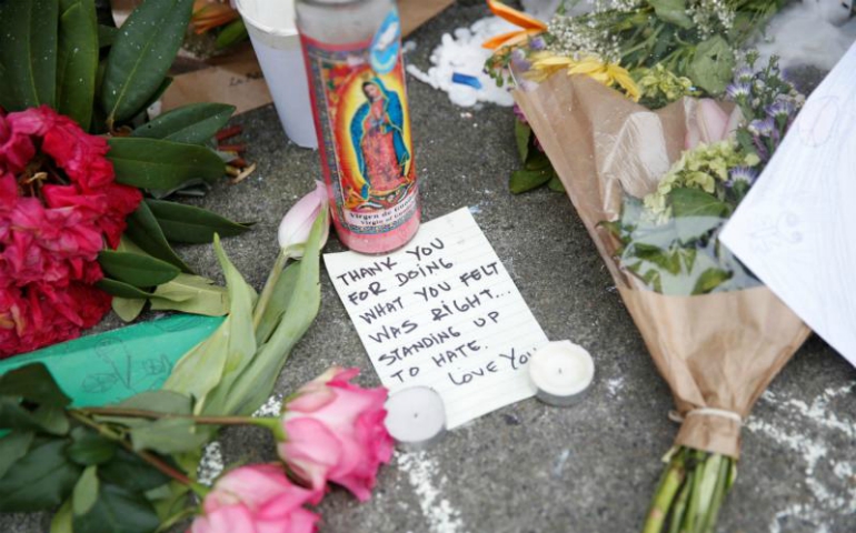 A candle with an image of Our Lady of Guadalupe is seen alongside a note and flowers at a makeshift memorial May 29 in Portland, Ore., for two men who were killed while they were trying to defend two women from a man yelling epithets against them aboard a commuter train. (CNS/Terray Sylvester, Reuters)