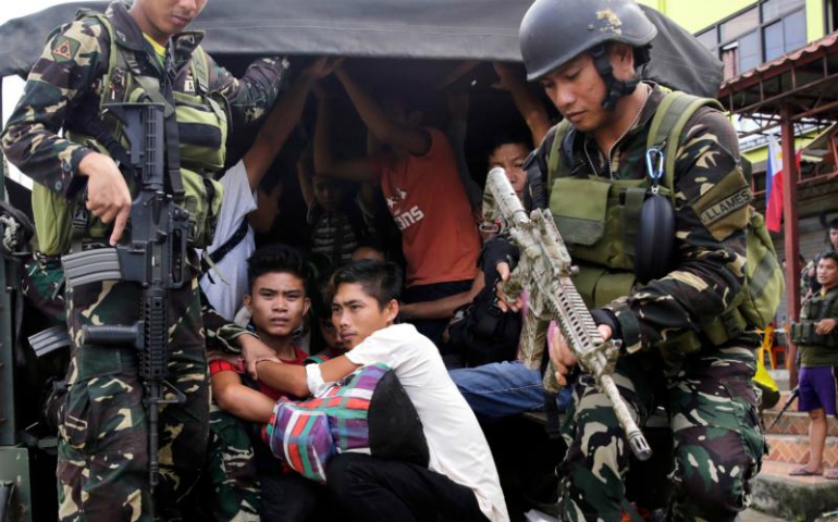 Filipino residents of Marawi are escorted to safety by government forces June 3. (CNS/Francis R. Malasig, EPA)