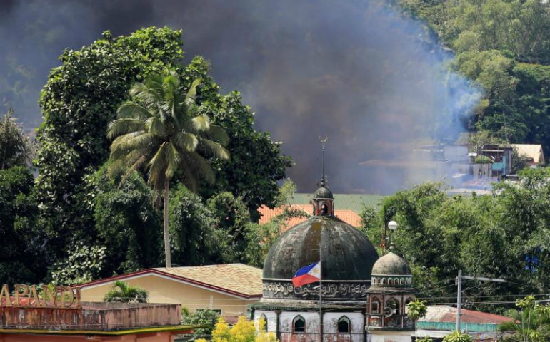 Smoke billows from a burning building near a mosque June 2 as government troops continued their assault on Islamic militants in Marawi, Philippines. (CNS/Romeo Ranoco, Reuters)