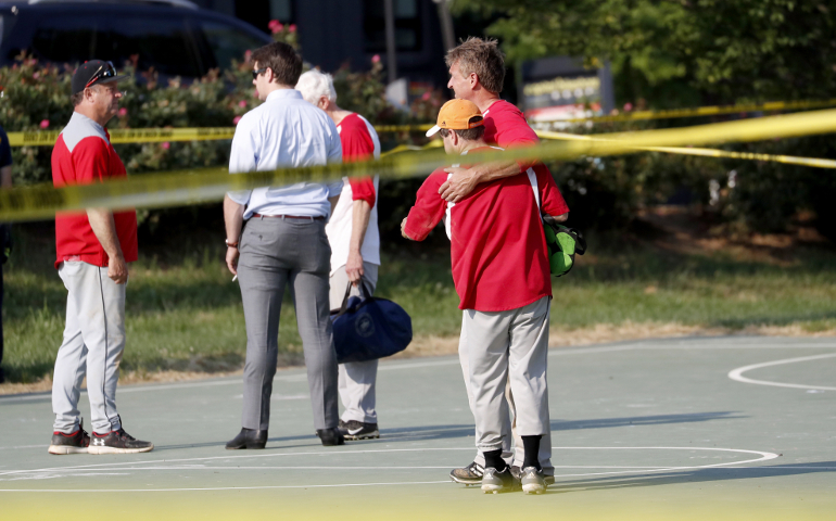 Sen. Jeff Flake, R-Ariz., hugs another member of the Republican congressional baseball team following a shooting in Alexandria, Va. U.S. House Majority Whip Steve Scalise, R-La., was shot while practicing baseball, according to news reports. (CNS/Shawn Thew, EPA)