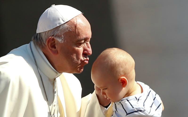 Pope Francis kisses a baby as he arrives for his general audience June 21 in St. Peter's Square at the Vatican. (CNS/Tony Gentile, Reuters) 