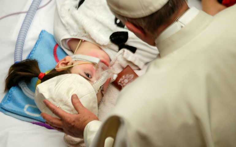 Pope Francis blesses a sick child in Paul VI hall at the Vatican Dec. 15, 2016, during a meeting with patients and workers of Rome's Bambino Gesu children's hospital. (CNS/Max Rossi/Reuters)