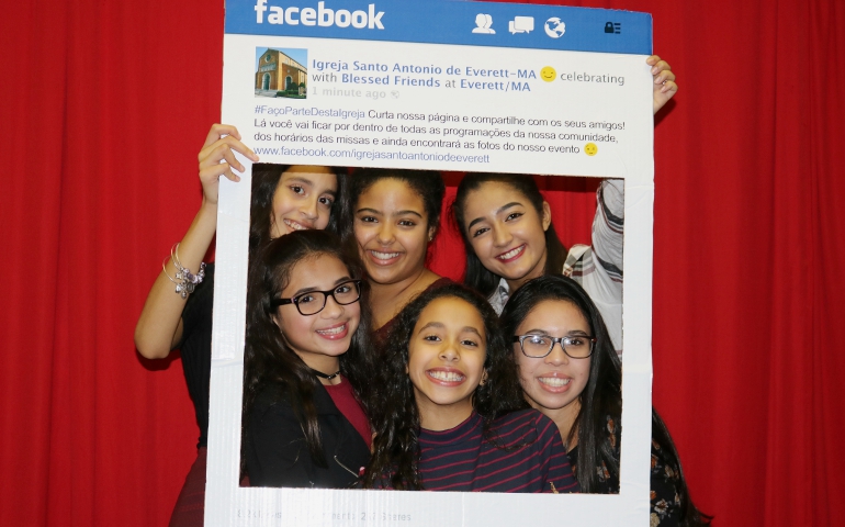 Young people from St. Anthony of Padua Parish in Everett, Massachusetts, pose with a Facebook frame promoting the parish Facebook page. (CNS/Courtesy of St. Anthony of Padua Parish Facebook page)