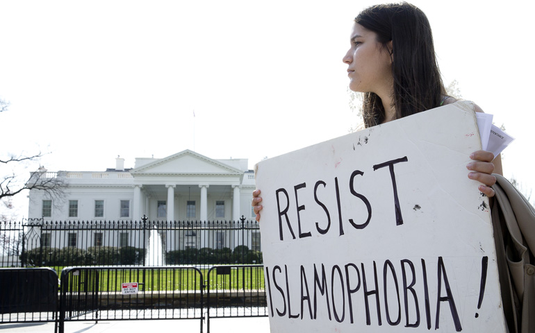 A peace activist holds a sign saying "Resist Islamophobia!" during a prayer service in early March outside the White House in Washington. (CNS/Tyler Orsburn)