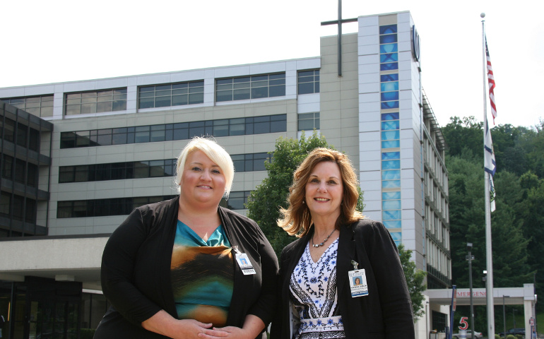 Heidi Porter, vice president of quality and regulatory affairs at Catholic-run Wheeling Hospital, and Kareen Simon, vice president of operations, pose for a photo outside the West Virginia hospital July 19. (CNS/Colleen Rowan, The Catholic Spirit)