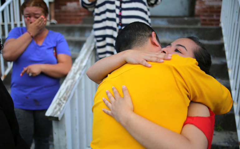 A teenage girl from El Salvador is embraced by a family friend before leaving Viva La Case refugee center with her family in Buffalo, N.Y., to file a claim July 5 with customs officials at the U.S.-Canadian border to remain in the United States. (CNS/Chris Helgren, Reuters)