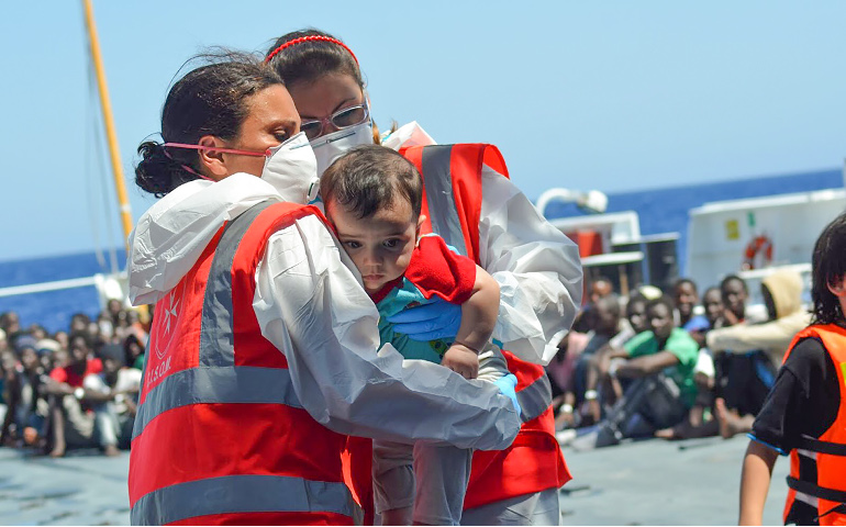 Volunteers of the Order of Malta's Italian Relief Corps provide assistant to an infant rescued in the Mediterranean Sea. (CNS/courtesy CISOM) 