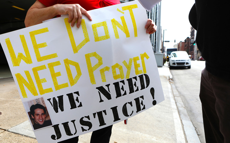 A woman holds this sign as members of the Survivors Network of those Abused by Priests hold a news conference in front of the Diocese of Pittsburgh Aug. 20, days after a Pennsylvania grand jury released a report that said more than 300 priests sexually abused more than 1,000 children over several decades. (CNS/Chaz Muth) 