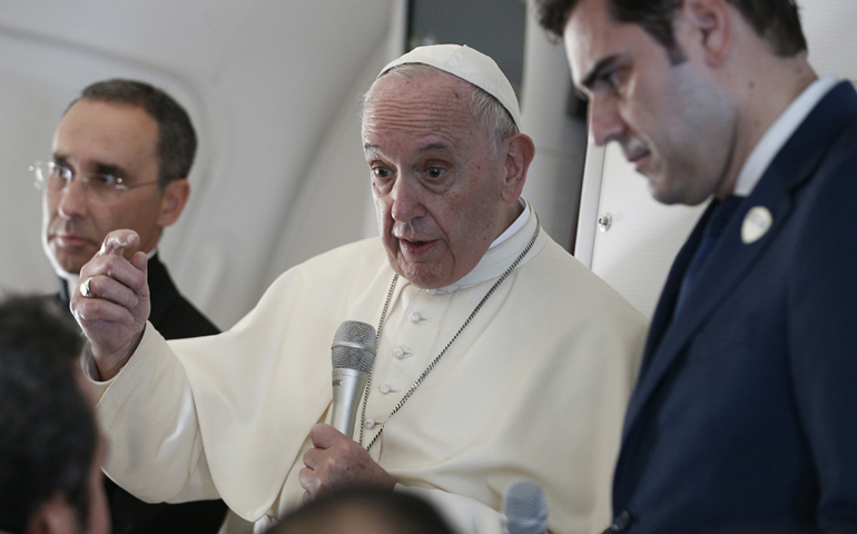Pope Francis answers questions from journalists aboard his flight from Abu Dhabi, United Arab Emirates, to Rome Feb. 5, 2019. Also pictured are Msgr. Mauricio Rueda, papal trip planner, and Alessandro Gisotti, interim Vatican spokesman. (CNS/Paul Haring)