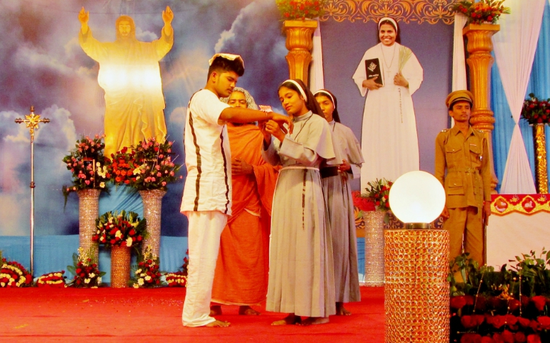 In a short play staged after the beatification of Sr. Rani Maria in Indore in the central Indian state of Madhya Pradesh Nov. 4, actors depict Sr. Selmy Paul, the younger sister of Blessed Rani Maria, tying a sacred thread on the wrist of Rani Maria's assassin, Samandar Singh, in jail in 2002 to accept him as her brother. (Saji Thomas)