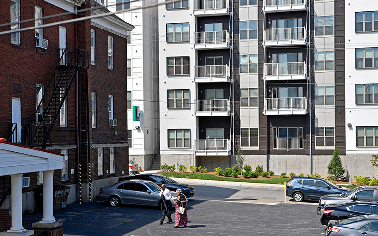 Worshippers arrive on July 16, 2017 for Sunday service at First Baptist East Nashville in Nashville, Tenn., with a backdrop of a new luxury apartment building next door. (Larry McCormack / The Tennessean)