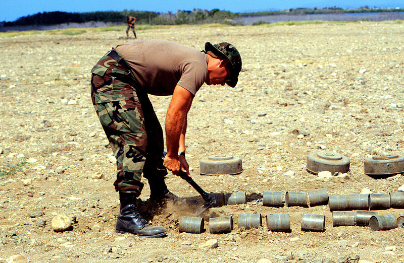  Petty Officer 1st Class Leon Ullel excavates an area to stack anti-tank and anti-personnel land mines for destruction at a demolition site at Naval Station Guantanamo Bay, Cuba. (Photo by United States Navy)