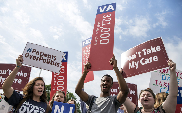 Supporters of the Affordable Care Act rally Thursday at the Supreme Court in Washington. (CNS/Reuters/Joshua Roberts)