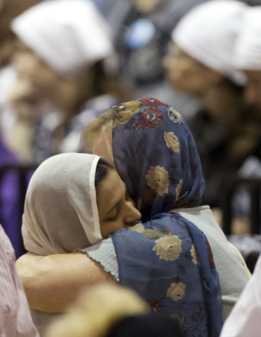 Mourners console one another at the funeral and memorial service for the six victims of the mass shooting at the Sikh Temple of Wisconsin. The public service was held Aug. 10, 2012, in the Oak Creek High School. (AP/Jeffrey Phelps)