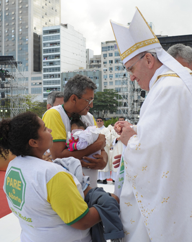 Pope Francis holds a replica of a fetus presented by a couple wearing T-shirts with "Stop Abortion" written on them in Portuguese during the offertory at the closing Mass of World Youth Day on July 28 in Rio de Janeiro. (CNS/L'Osservatore Romano)
