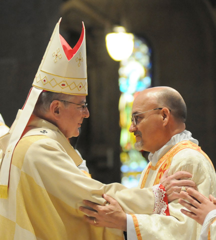 Archbishop John Nienstedt of St. Paul and Minneapolis offers the sign of peace to Fr. Vaughn Treco on May 2 at the Basilica of St. Mary in Minneapolis. (CNS/The Catholic Spirit/Dianne Towalski)